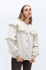 Campera de jean gris oscuro con volados en el frente y las mangas, cierre con botones metálicos.