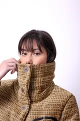 Campera corta con estampado abstracto en tonos marrones y beige, cuello alto, cierre frontal con botones a presión, bolsillos delanteros y bordado negro con las iniciales CP. Forro interior y relleno liviano de guata.