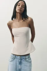 Top bandeau color marrón de tejido de punto elástico y flexible, con trama compacta, mullida y opaca. Escote recto y hombros descubiertos.