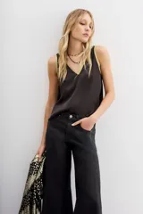 Top negro de viscosa con escote en V y detalle de lurex dorado en los bordes.
