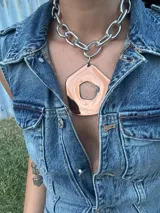 Collar con cadena plateada de eslabones grandes y dije abstracto desmontable de acrílico y resina color cobre.