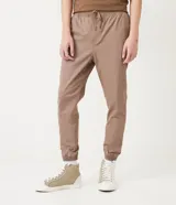 Pantalón jogger color marrón claro, con cintura elástica, cordón de ajuste y bolsillos laterales.