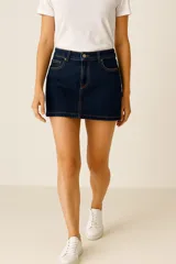 Falda corta de jean, color azul oscuro, de corte recto, con costuras en contraste color naranja y cinco bolsillos.