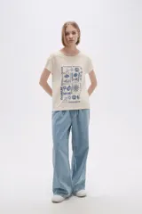 Remera color crema con estampado de motivos playeros en color azul.