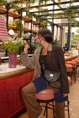 Blazer oversize con diseño asimétrico, mitad en tela a cuadros gris y blanco, mitad en tela lisa gris. Tiene solapas, cierre con botones y pin de salchicha decorativo.