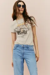 Remera de algodón color beige con cuello redondo y estampado de un auto Camaro con texto en tonos marrones y naranjas.