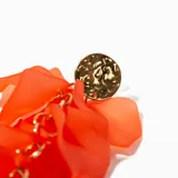 Aros colgantes naranjas con forma de pétalos y detalles dorados.