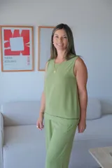 Musculosa sin mangas color verde claro, con escote redondo y breteles anchos. Presenta un detalle de pespunte decorativo en el ruedo inferior.
