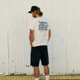 Remera de manga corta color blanco hueso con cuello redondo y estampado pequeño en el pecho con el logo de la marca Katin y la leyenda 'Customs' en azul.