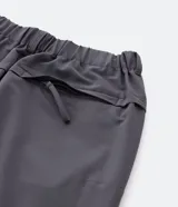 Pantalón gris estilo parachute, corte ancho, con cintura elástica, bolsillos laterales y tobillos ajustables con cordón.