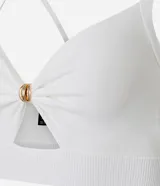 Top super cropped color crudo, de punto, con escote en V, breteles finos y adorno de nudo con aro dorado en el busto.