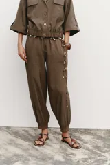 Pantalón de jogging color marrón, de tiro medio con cintura elástica ajustable con cordones, bolsillos delanteros y puños elásticos en los tobillos.