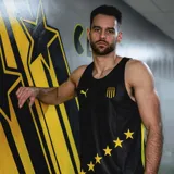 Musculosa deportiva negra con detalles en amarillo, escudo del Club Atlético Peñarol y logo de Puma.