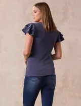 Remera beige de tejido acanalado, con cuello redondo y mangas cortas con volados.