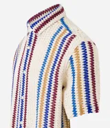 Camisa de manga corta con cuello alto y abotonada, confeccionada en ganchillo rústico con textura.