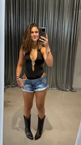 Body negro con escote halter, abertura en el pecho y aplique metálico dorado.