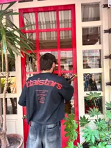 Remera color crema de corte holgado con estampado en rojo en la espalda con el texto "Ittaistars European Tour by Ittai Stars Company".