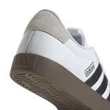 Championes Adidas VL Court 3.0, color blanco con detalles en negro y suela marrón. Inspirados en el skate, con exterior de cuero y gamuza, las tres tiras clásicas de Adidas en los laterales y suela vulcanizada.