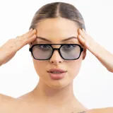 Lentes de sol con marco negro, patillas plateadas y lentes celestes.