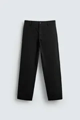 Pantalón relaxed fit color negro confeccionado en tejido de algodón con elasticidad. Cuenta con bolsillos frontales y traseros de vivo. Tiene efecto lavado y cierre frontal con cremallera y botón.