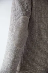 Chaqueta corta color marrón con cuello solapa y diseño con patchwork de telas. Manga larga con detalle de coderas aplicadas. Cierre frontal mediante botones y bolsillos ojal. Con forro.