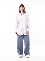 Camisa blanca a rayas verticales, de corte clásico y mangas 3/4.