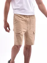 Bermuda color beige, de corte recto, con bolsillos cargo laterales y cintura elastizada con cordón ajustable.