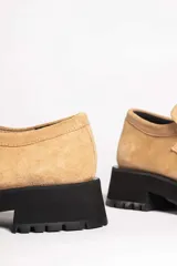 Mocasín de gamuza color verde oliva, con tira superior y suela track gruesa y negra.