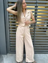 Conjunto color crudo compuesto por chaleco corto con solapas y pantalón palazzo de tiro alto.