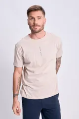 Remera de manga corta color beige con estampado vertical "Human Nature" en el frente.