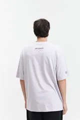 Remera de manga corta color lila, corte oversize, con escote redondo y lettering estampado en el frente.