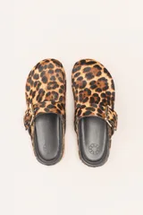 Sueco destalonado de cuero vacuno color negro, con hebilla ajustable dorada y detalles de tachas doradas.