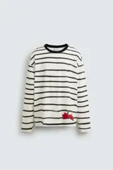 Camiseta relaxed fit de manga larga confeccionada en tejido compacto de algodón a rayas horizontales blancas y negras. Tiene cuello redondo y detalle de estampado de flores rojas en el bajo. Edición especial Zara x Otis Kwame Kye Quaicoe.