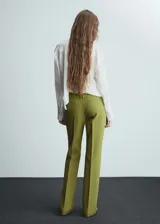Pantalón de vestir verde oliva de tiro bajo y corte acampanado. Con trabillas, bolsillos traseros de ribete y cierre oculto de botón, gancho y cremallera.