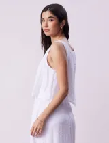 Vestido largo color mostaza de crepe, marca Marissa Olivia. Escote redondo con sobrecapa y detalle de crochet en los hombros. Corte en la cintura con punto smock. Sin mangas.