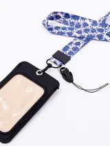 Llavero porta tarjeta con cinta estampada con diseño de hojas en tonos beige, azul y violeta.