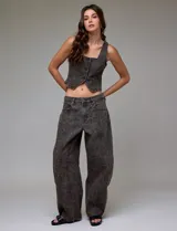Pantalón de jean tiro alto con corte wide leg, confeccionado en denim gris oscuro con estampado de leopardo sutil. Presenta recortes verticales frontales y ruedo deshilachado.