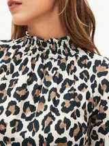 Vestido corto negro con cuello alto, mangas largas abullonadas y falda escalonada.