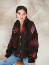 Saco de lana marrón con diseño geométrico multicolor, cuello con solapa, cierre frontal con botones y bolsillos delanteros.