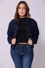 Campera de jean de color azul oscuro, con corte cropped y costuras en contraste color caramelo. Presenta cuello clásico, cierre frontal con botones metálicos y bolsillos a la altura del pecho y laterales.