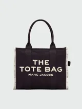Bolso tote grande Marc Jacobs, confeccionado en tejido jacquard negro con asas y detalles en blanco. Presenta el logo "THE TOTE BAG MARC JACOBS" estampado en el frente.