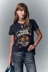 Remera negra de algodón con teñido vintage y corte ajustado. Estampa central con diseño de serpiente con detalles bordados en hilo de lurex y mostacillas.