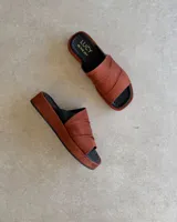 Sandalia de cuero vacuno color negro con tira ancha sobre el empeine y base plana.