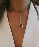 Collar minimalista dorado con dije colgante de bronce con cuentas blancas y marrones.