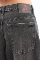 Pantalón de jean negro de corte ancho con costuras marcadas en las rodillas.