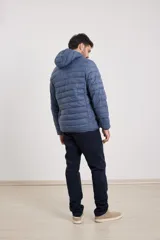 Campera capitoneada color bordó con capucha desmontable con cierre, dos bolsillos exteriores con cierre y un bolsillo interior.