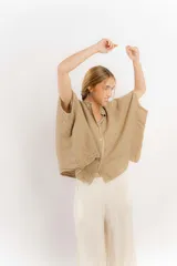 Camisa color beige de lino con mangas amplias y cinta en tono más oscuro.