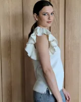 Musculosa blanca de punto con cuello redondo y mangas con volados.