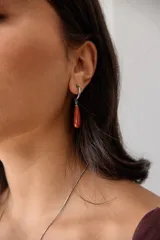 Aros colgantes de acero quirúrgico hipoalergénico con dije de piedra natural en forma de gota color azul oscuro.