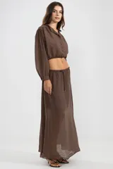 Blusa corta color marrón chocolate en tejido arrugado liviano, con cuello mao, botones al frente y mangas abullonadas terminadas con ruedo elastizado.